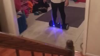 White shirt woman falls off hoverboard in front of stairs