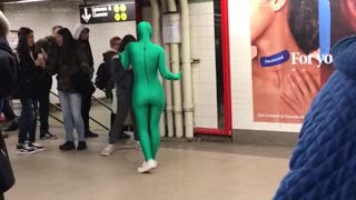 Person i green body suit dancing to theme song