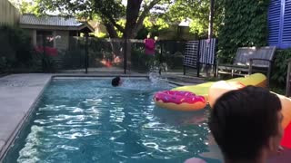 Guy white shirt tries to jump across pool but does split at edge of pool donut toy