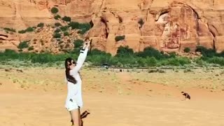 Girl trying to keep kite from flying away gets carried and faceplants on sand