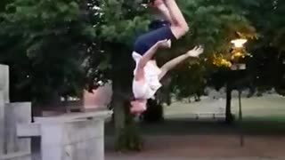 Guy slow motion backflip off of wall lands on butt bends arm
