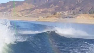 Red wakeboard tries to jump wave and faceplants behind boat