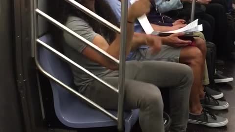 Man with long curly hair bobbing head on train