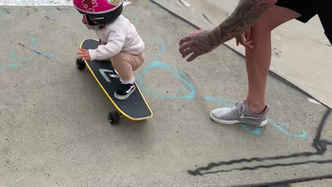 Young Girls Showcases Skateboard Skill with Dad's Help