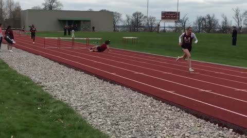 A girl in red falls off hurdle in high school track field