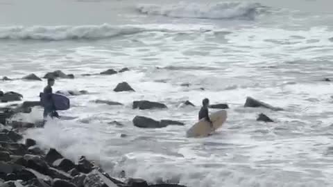 Guy paddles out to water then comes back