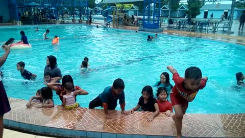 Kids climbing up from swimming pool