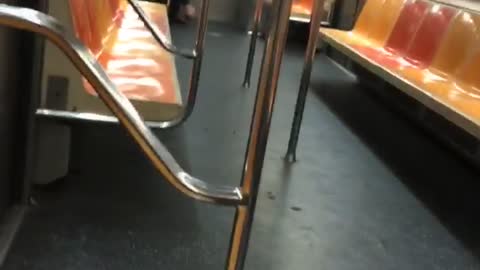 Man picking his bare feet on empty subway train