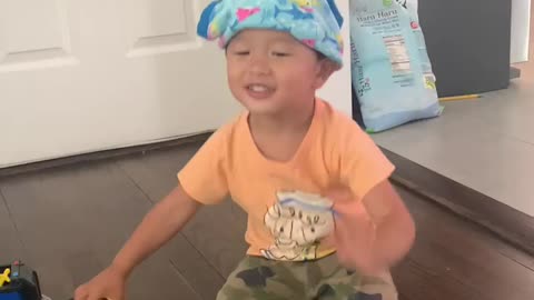 A toddler wearing cute baby underwear on his head.