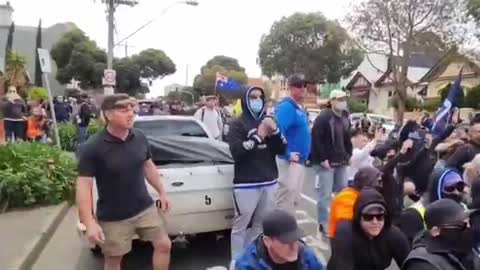 Australia: Protesters sit, put hands up in front of police line