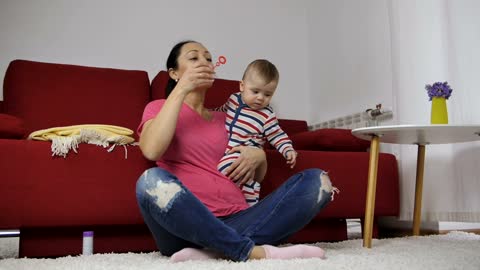 Mother blowing bubbles with her baby