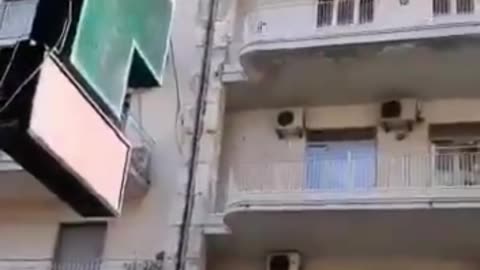 Chaos in Catania Sicily. A half-naked woman throws everything from the balcony