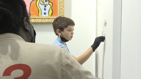 Niño prodigio pinta un cuadro en vivo y rodeado de gente en Art Miami