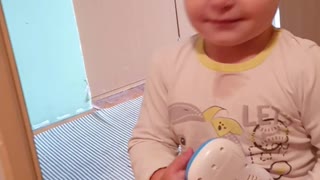 Baby is playing with a toy and smiling