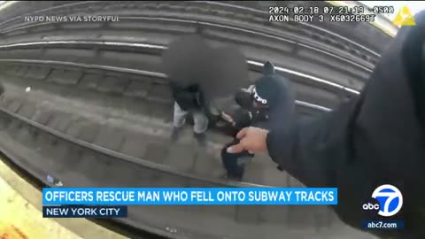 Police officers take quick action after a man fell onto subway tracks
