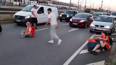 Motorist drags and kicks climate change protesters blocking a busy highway in Germany