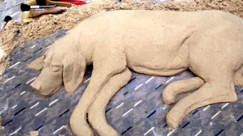 Street artists sculpts realistic sand "dog"