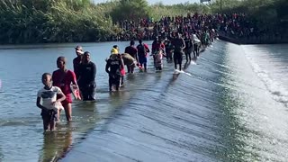 Migrants cross the Rio Grande en route to illegally enter Del Rio, Texas.