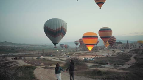Couple Walking Down The Road Towards The Hot-Air Balloon Festival