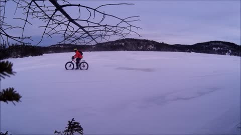 Fat bike ride by on frozen ice and snow