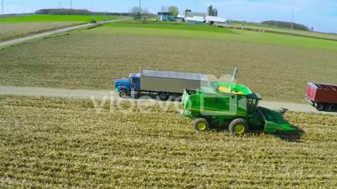 Excellent aerial over a rural American farm with corn combine harvester at work 2