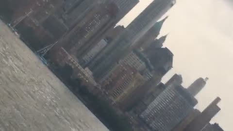 A man in a suit paddle boards on hudson river in new york