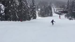 Black jacket snowboard guy falls on butt going down hill