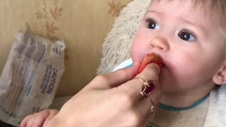 Child eating sour tomato