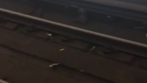 Baby shoes and wrist watch on a subway train track