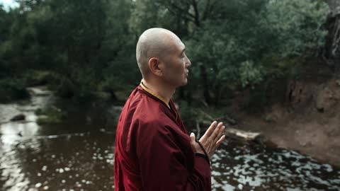 A Buddhist Monk Praying Outdoors