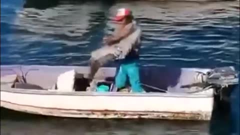 Fisherman gives pelican a friendly hug 😊