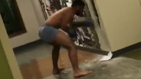 Shirtless guy black gloves punches holes in wall