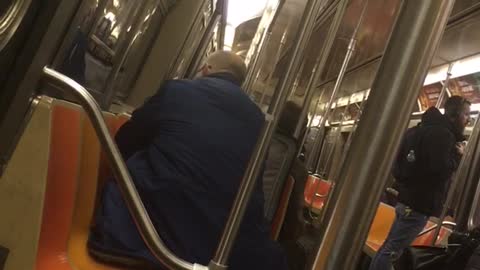 Man drags his suitcase onto subway and unpacks it