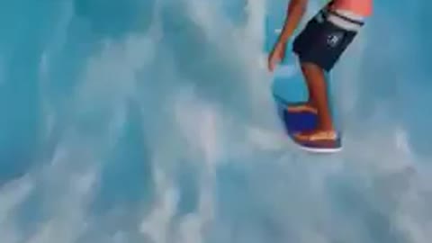 Shirtless guy surfs wave ride machine faceplants in water