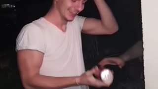 Guy white shirt opening beer with head and shotgunning it