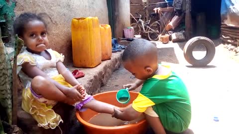 Ethiopian Kids a Little Kids washing her foot