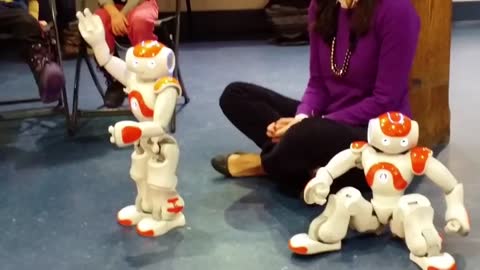 Two miniature robots dance to music