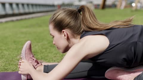 Woman stretching on grass FDH