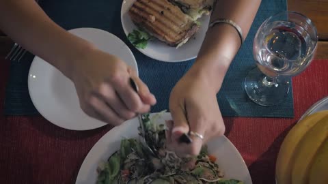 Woman eating salad and sandwich