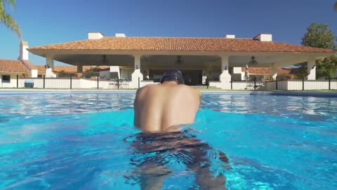 Swimmer in the pool seen from behind