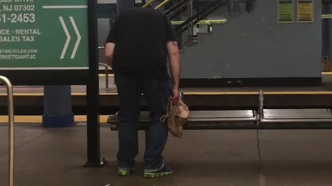 A man in black shirt slowly bending down