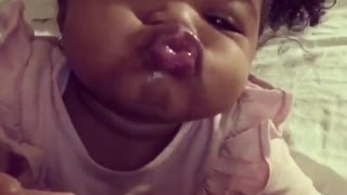 Baby humorously puckers up for adorable kiss