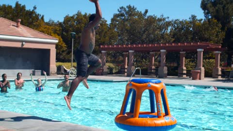 A-man-dunking-the-ball-in-a-pool-floating-basket