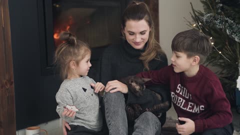 Family With Cat in Front of Fireplace