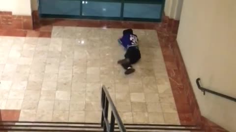 Man in blue jersey goes down stair rails falls