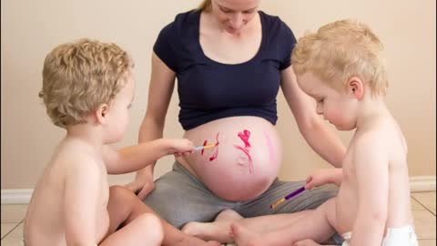 Twins paint mommy's pregnant belly