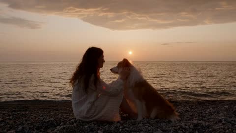 portrait Lonely brunette woman playing at the beach with her dog at sunset