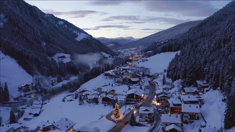 flying over beautiful winter ski resort town of val gardena in italy