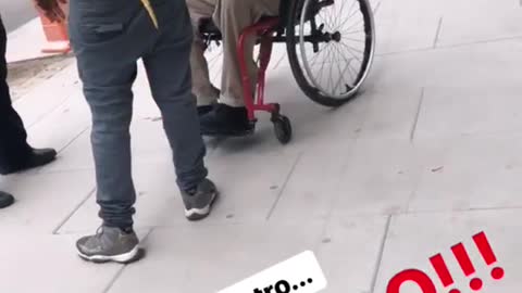 Man holds yellow boa constrictor for guy on wheelchair to pet, snake was on the metro