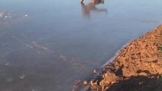 Guy in brown jacket running on frozen lake falls